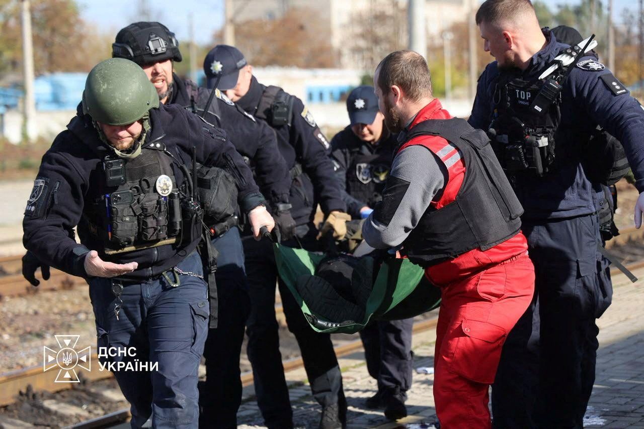 <i>State Emergency Service of Ukraine/Reuters via CNN Newsource</i><br/>A paramedic and police officers carry a person injured at a railway station during a Russian drone strike