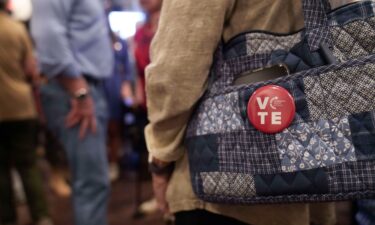 A woman wears a Turning Point Action pin on her bag on October 12