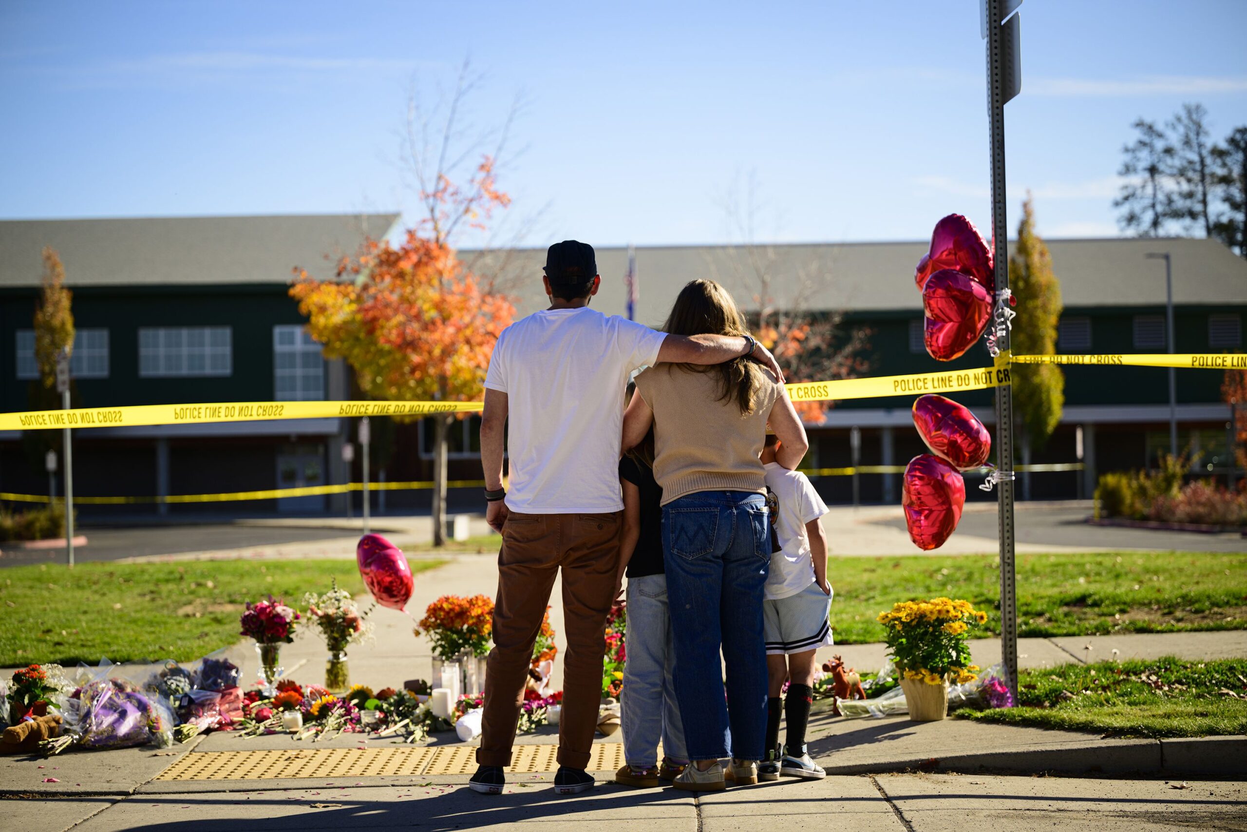 <i>Mathieu Lewis-Rolland/Getty Images via CNN Newsource</i><br/>Community members grieve at the site of a makeshift memorial in front of Silver Rail Elementary School in Bend