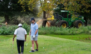 Crews cut down trees on East Potomac Golf Course as golfers continue to use the course in Washington