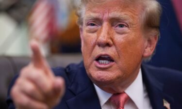 President Donald Trump gestures as he speaks to reporters in the Oval Office of the White House.