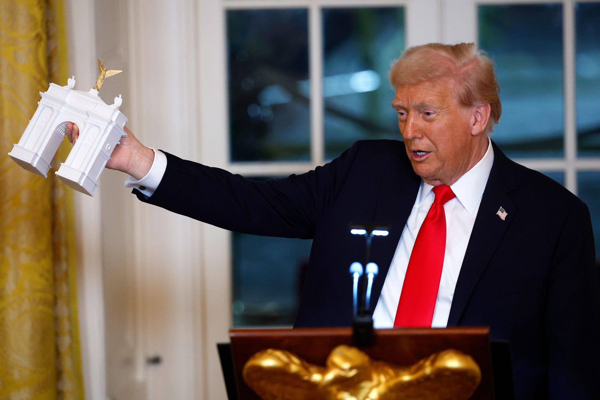 <i>Kevin Dietsch/Getty Images/File via CNN Newsource</i><br/>President Donald Trump holds a model of his proposed triumphal arch as he delivers remarks during a ballroom fundraising dinner in the East Room of the White House on October 15