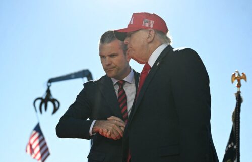 US President Donald Trump (R) shakes hands with Secretary of Defense Pete Hegseth as he arrives to speak at Anduril Industries in Sparrows Point